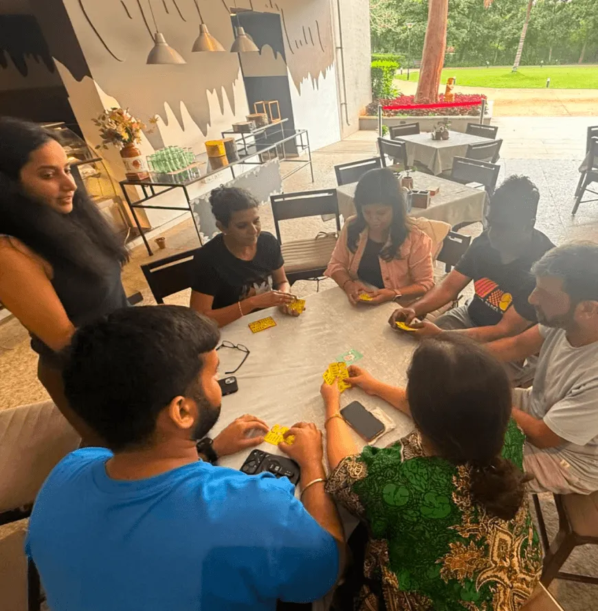 Artium teammates playing a board game around a table