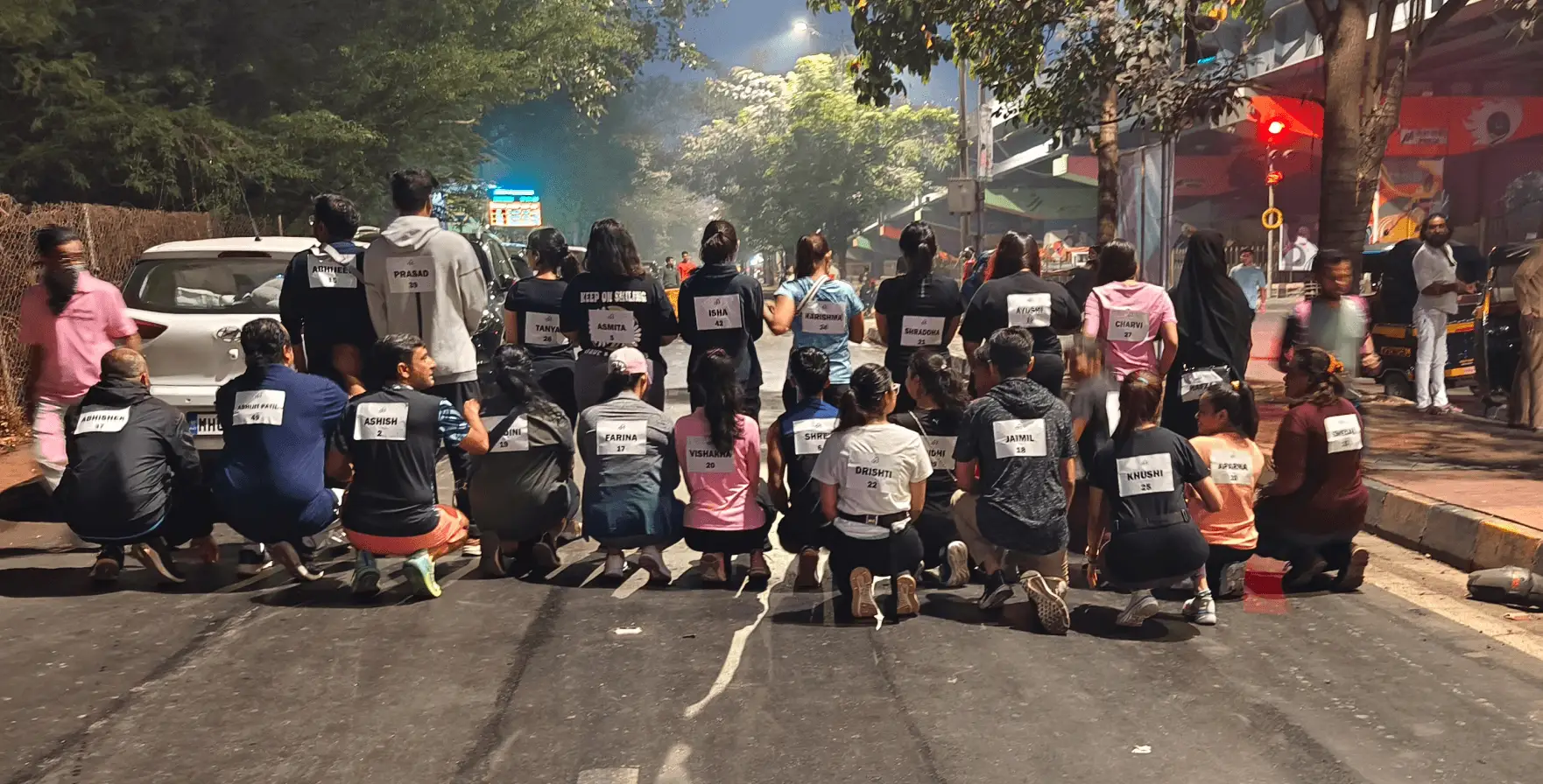 The Artium team kneeling together on the road at the Get Fit Marathon