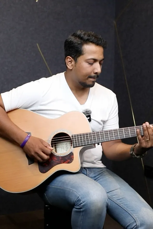 An Artium guitar learner playing acoustic guitar