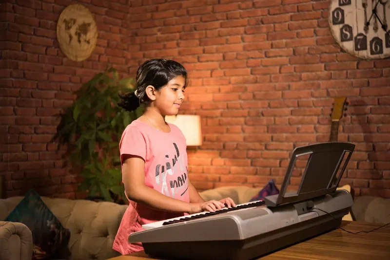 A young learner playing the keyboard at home