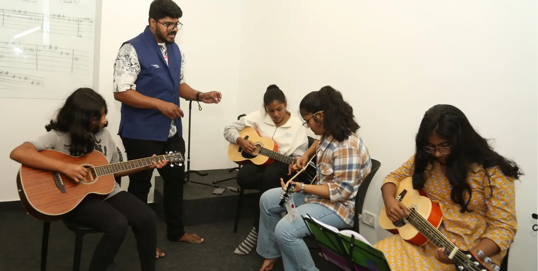 Learners playing guitar in an Artium guitar classroom