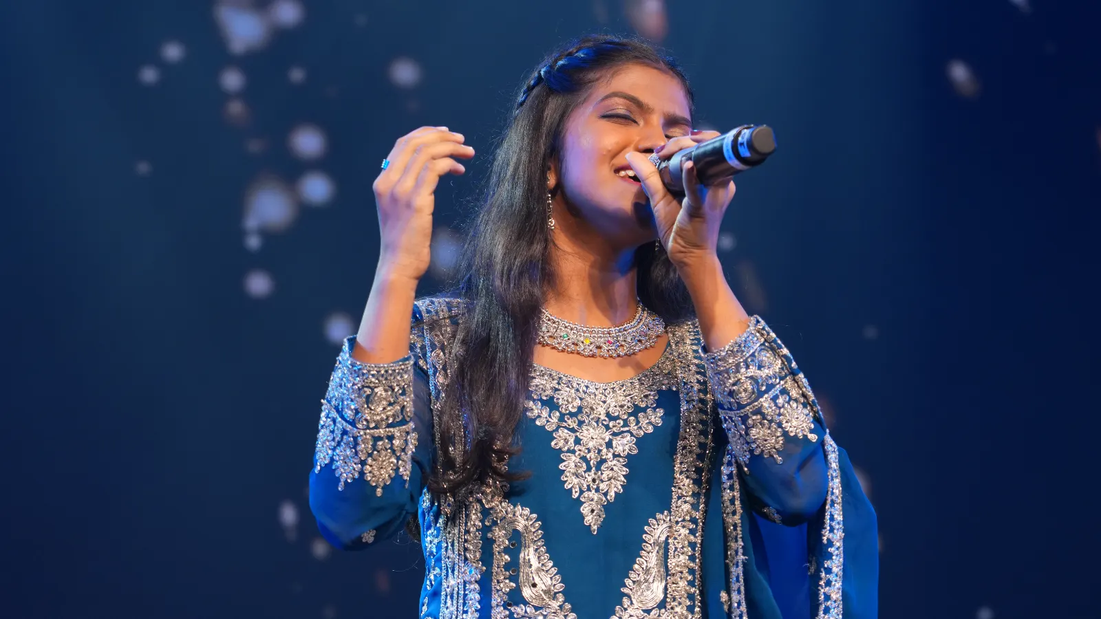 An Artium learner singing on stage