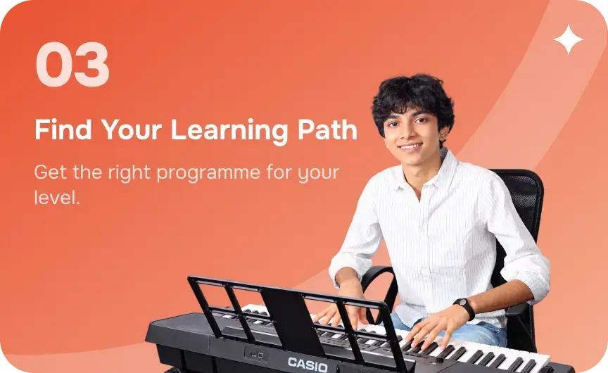 A teenage student smiling at a keyboard