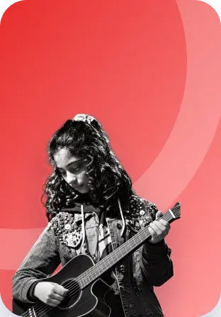An Artium artist in a denim jacket playing the guitar