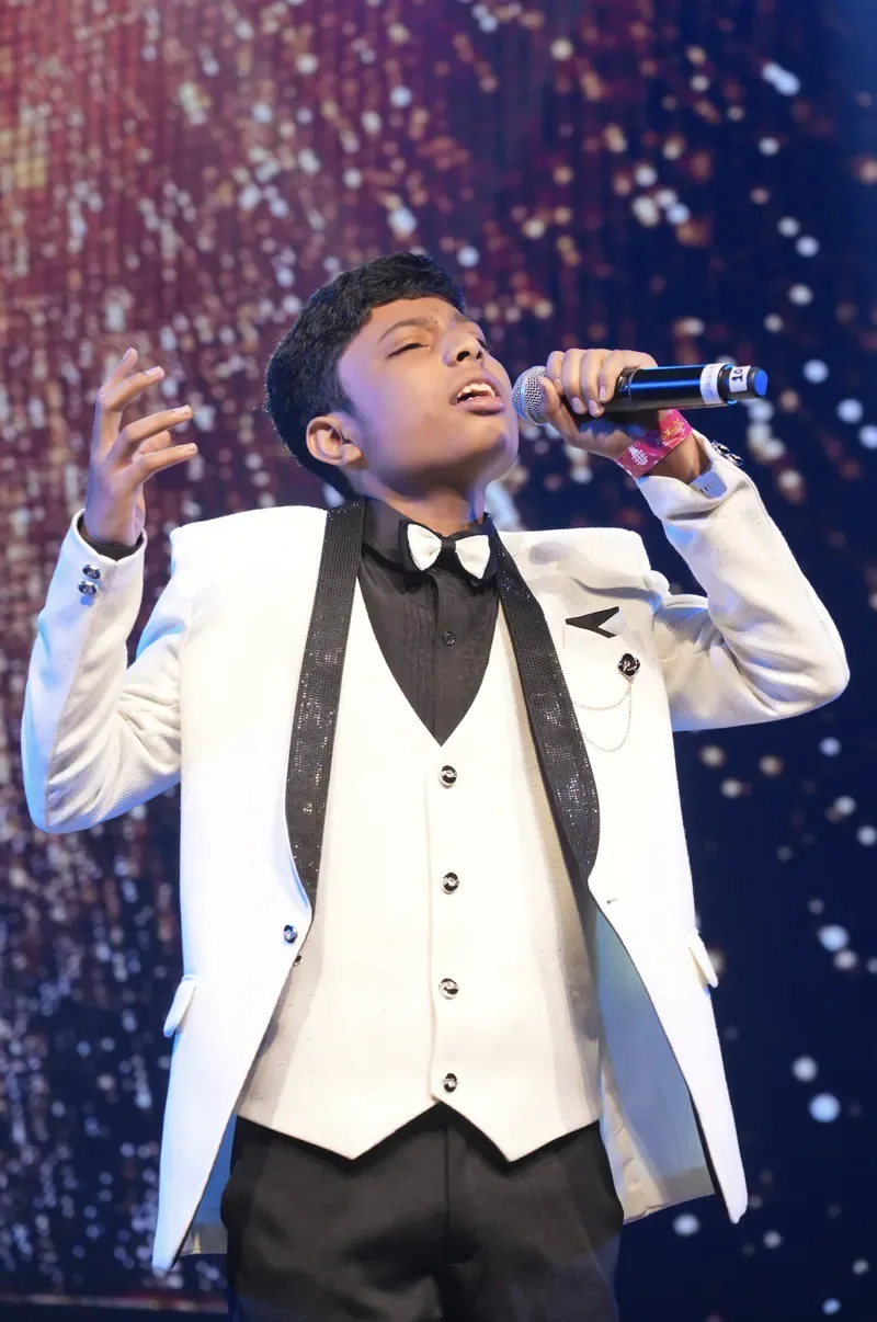 A young Artium learner singing on stage