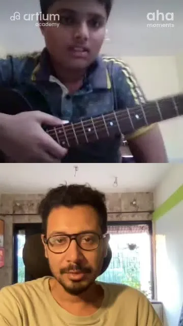 A young learner playing the guitar with his teacher in a live class