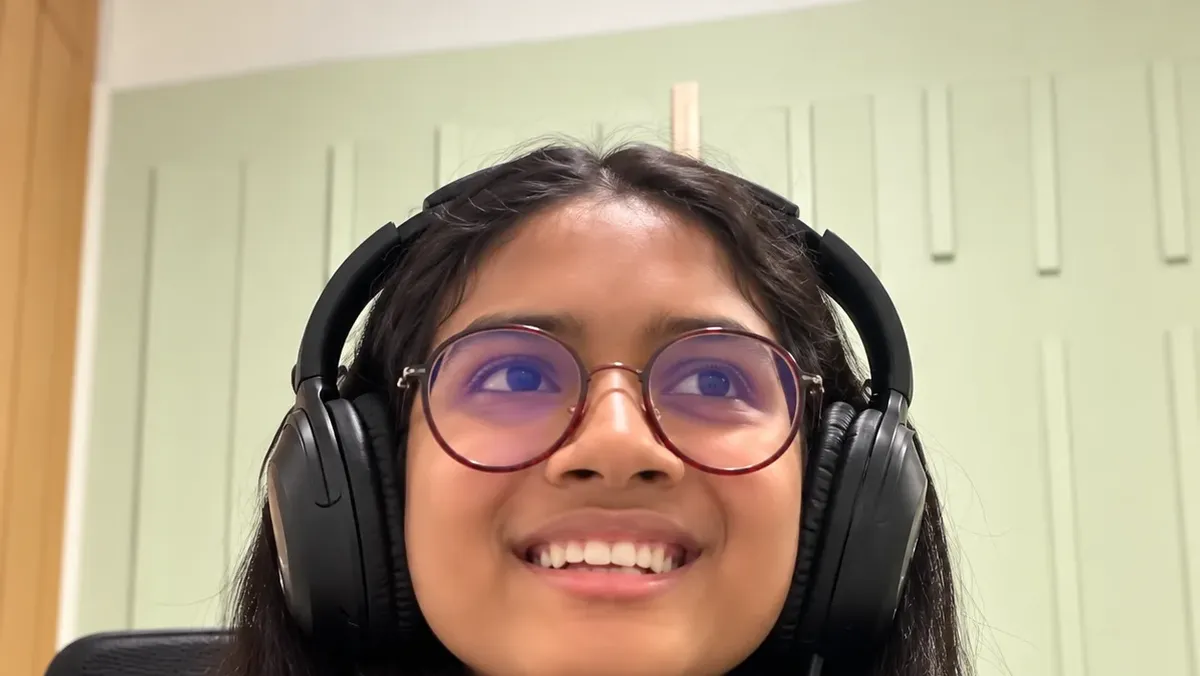 Saanvi singing a South Indian song with headphones at Artium Showcase