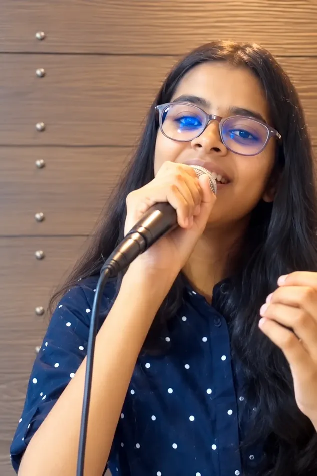 Devanshi Sarangi singing into a microphone at Artium Showcase
