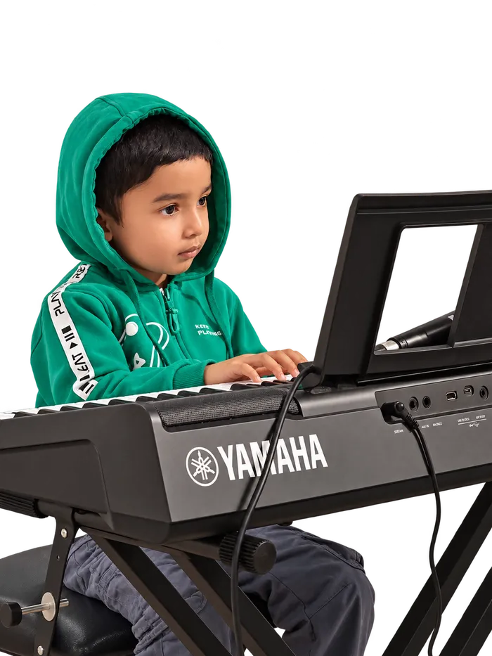 A young Artium learner playing the keyboard